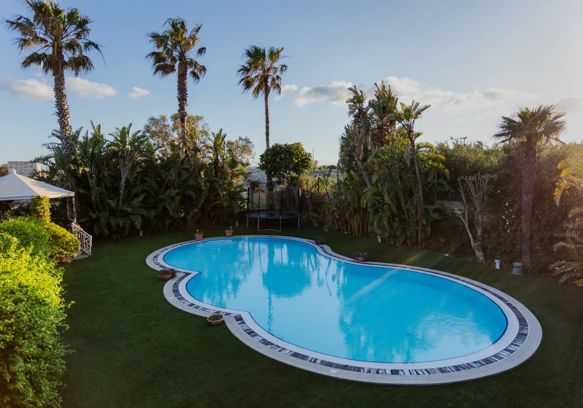 Aerial view of Nine Angels Villa lagoon pool and palm gardens, Madliena Malta
